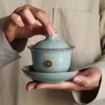 Full product shot of 160ml blue ice crack ceramic gaiwan tea cup with lotus decoration