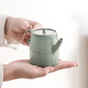175ml celadon ceramic teapot with infuser held in hands size reference