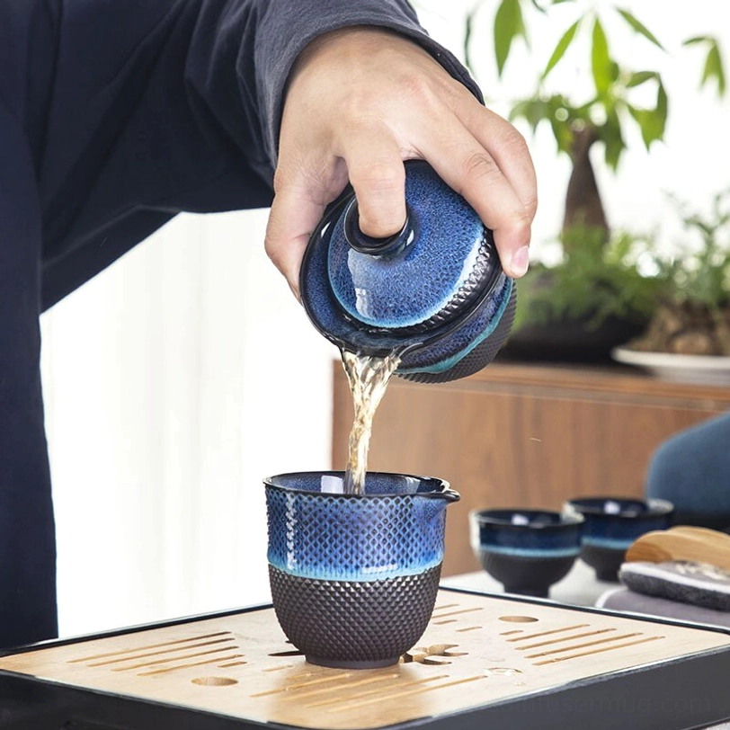all components of blue ceramic travel tea set arranged together