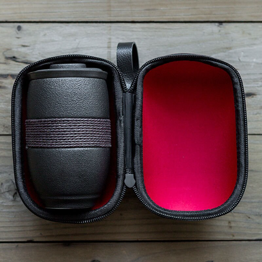 all components of travel tea set laid out: cup, infuser, lid, bag