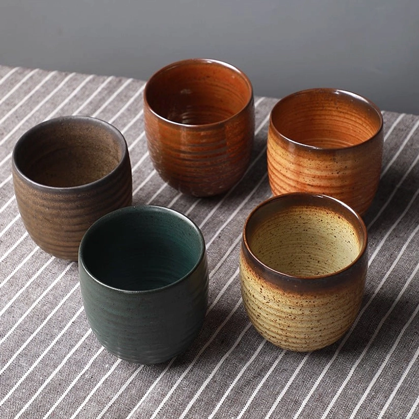 all 6 styles of vintage Chinese clay tea cups arranged on wooden table