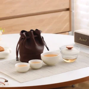 beige travel tea set with glass gaiwan and three ceramic cups