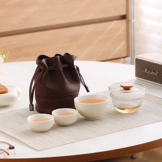 beige travel tea set with glass gaiwan and three ceramic cups