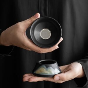Hand-painted landscape black ceramic tea strainer set with fine metal mesh on tea table