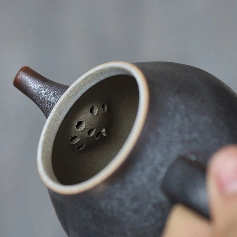 close up of built-in infuser filter on the black ceramic teapot