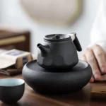 black clay teapot with rope wrapped handle and built-in infuser