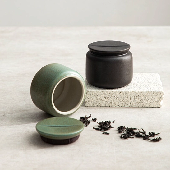 two ceramic tea storage canisters black and green displayed together