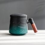 black-green gradient ceramic tea mug with lid and strainer showing mountain relief pattern