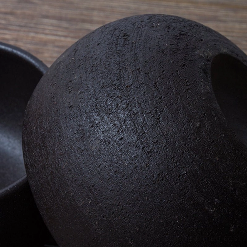 black japanese ceramic tea cup placed on wooden tea tray