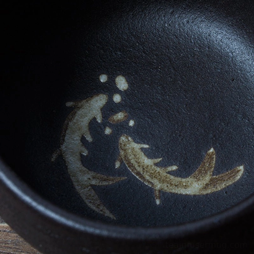 black japanese ceramic tea cup holding brewed tea