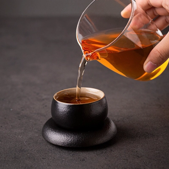 Bottom view of the textured black Japanese tea cup showing the base