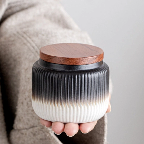 black ceramic loose leaf tea storage canister on neutral background