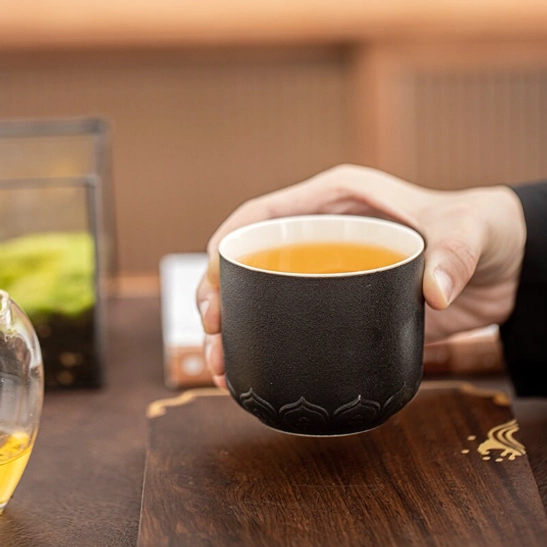 bottom view of black chinese tea cup showing carved fu blessing character relief