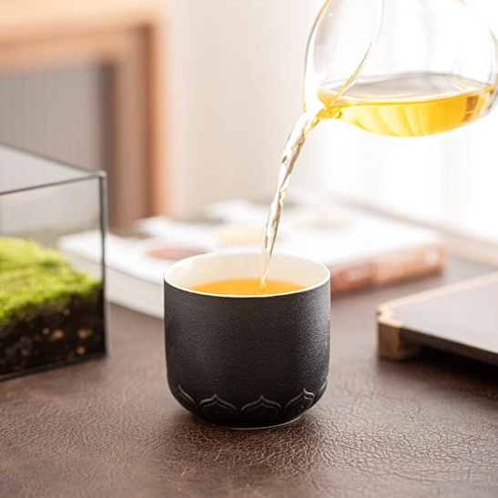 black chinese porcelain tea cup held in hand showing size and grip comfort