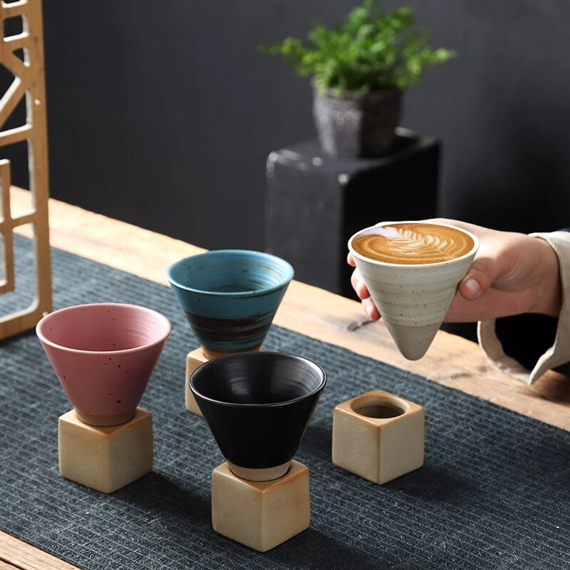 Side profile of blue striped Japanese ceramic tea cup on beige square base
