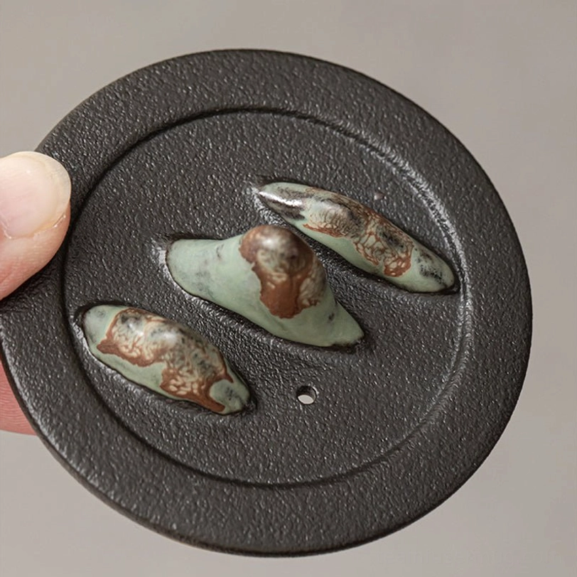 close up of brass handle on mountain ceramic teapot with infuser