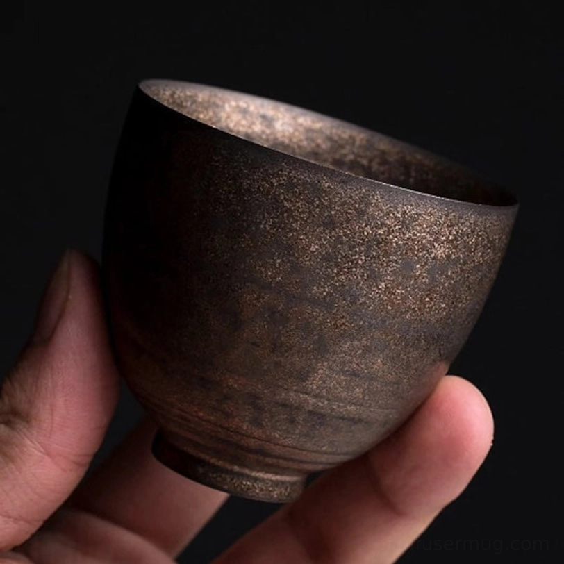 vintage bronze chinese tea cups arranged on a wooden tea table