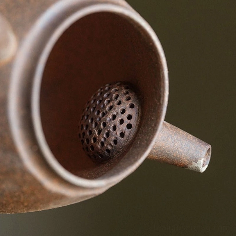 Close up of built-in infuser filter holes inside vintage clay teapot