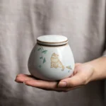 side view of white cat ceramic sealed tea canister with crackle glaze