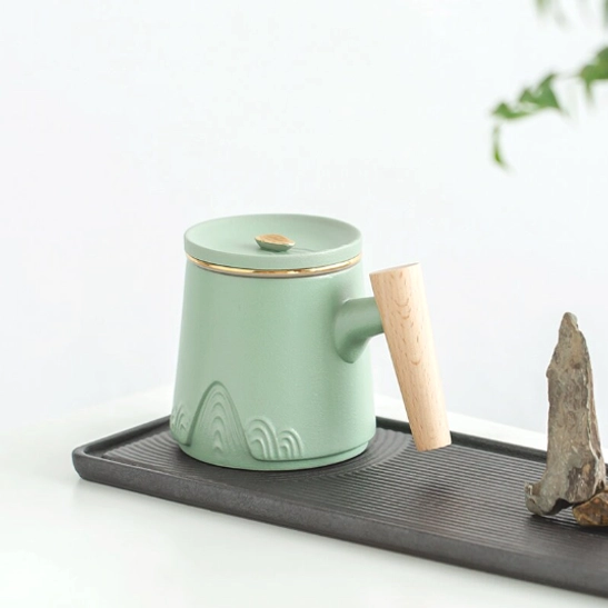 Side view of ceramic tea infuser mug showing relief mountain carving