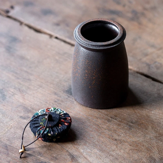 ceramic tea storage canister held in hand to show size and shape