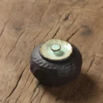 small textured dark brown ceramic tea storage canister with celadon lid