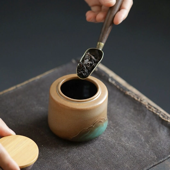 ceramic tea storage canister placed on wooden tea table