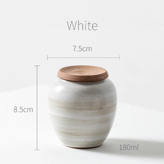ceramic tea storage canister displayed with dried tea leaves