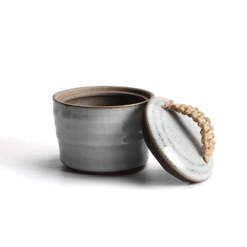 ceramic tea storage canister with loose leaf tea next to it