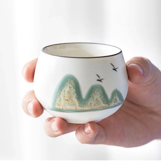 close up of mountain and bird pattern on chinese ceramic tea cup