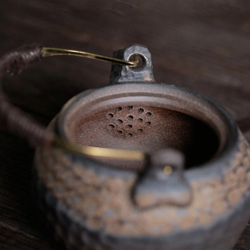 close up of wrapped brass heat-resistant handle on chinese ceramic teapot