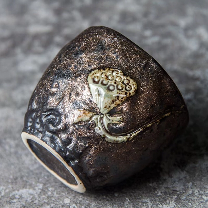 Side profile of dark rustic Chinese clay lotus tea cup showing natural texture