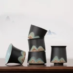 collection of mountain landscape ceramic chinese tea cups on wooden table
