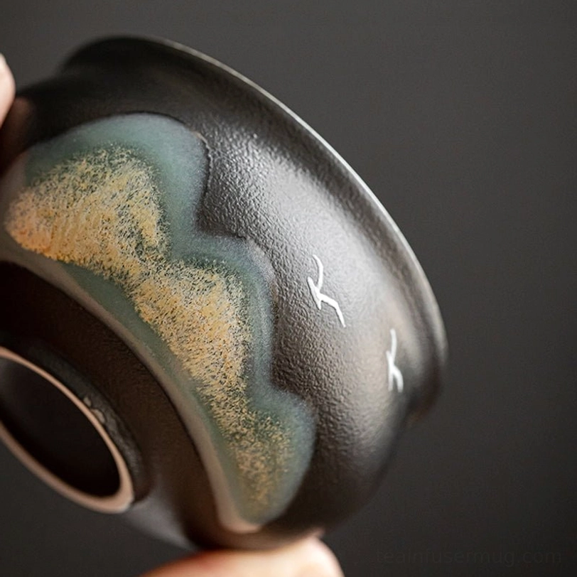 close up of ink wash landscape painting on black chinese tea cup