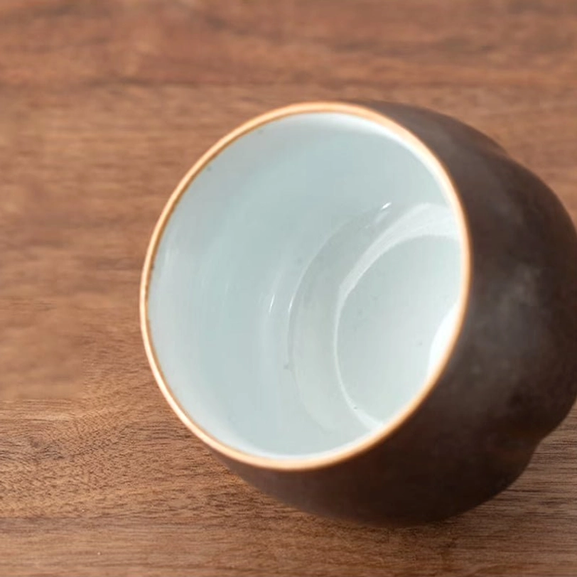 close up of chinese ceramic tea cups showing distinct mixed colors and gold rims