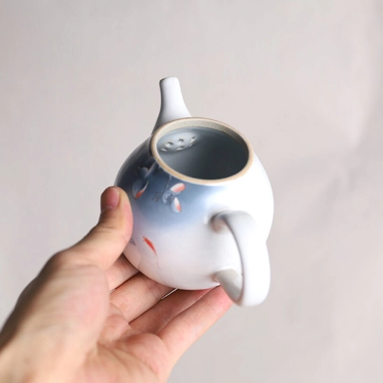Side view of Chinese ceramic teapot showing ergonomic handle and drip-free spout