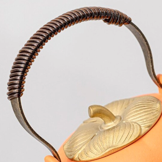 close up of persimmon tea pot with golden persimmon calyx lid