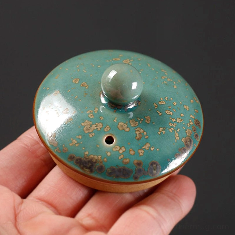 close up of natural speckled glaze on green ceramic teapot