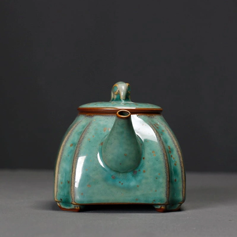 close up of built-in strainer infuser inside the green ceramic teapot