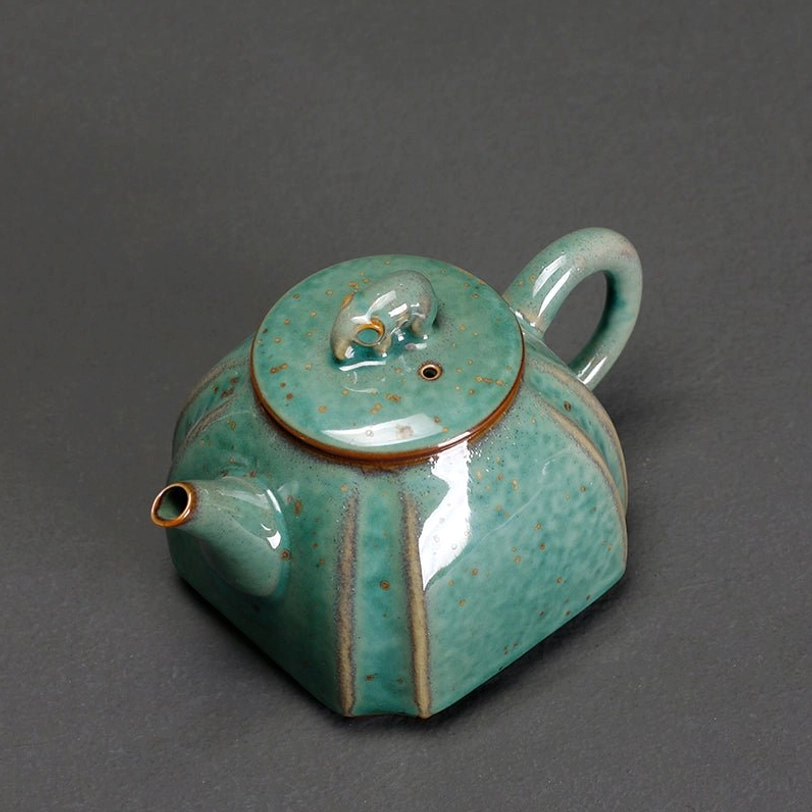 close up of elephant lid knob on ceramic teapot with infuser