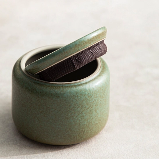 ceramic tea storage canister held in hand to show compact size