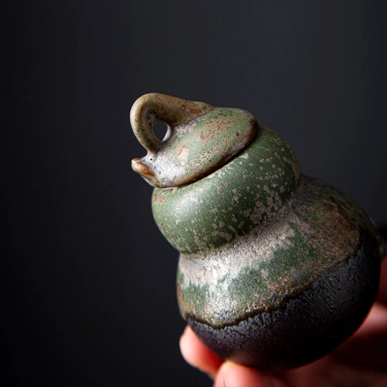 60ml gourd tea canister held in palm showing compact size