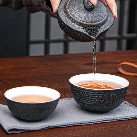 Complete unboxed travel tea set including teapot, two cups, towel and travel bag