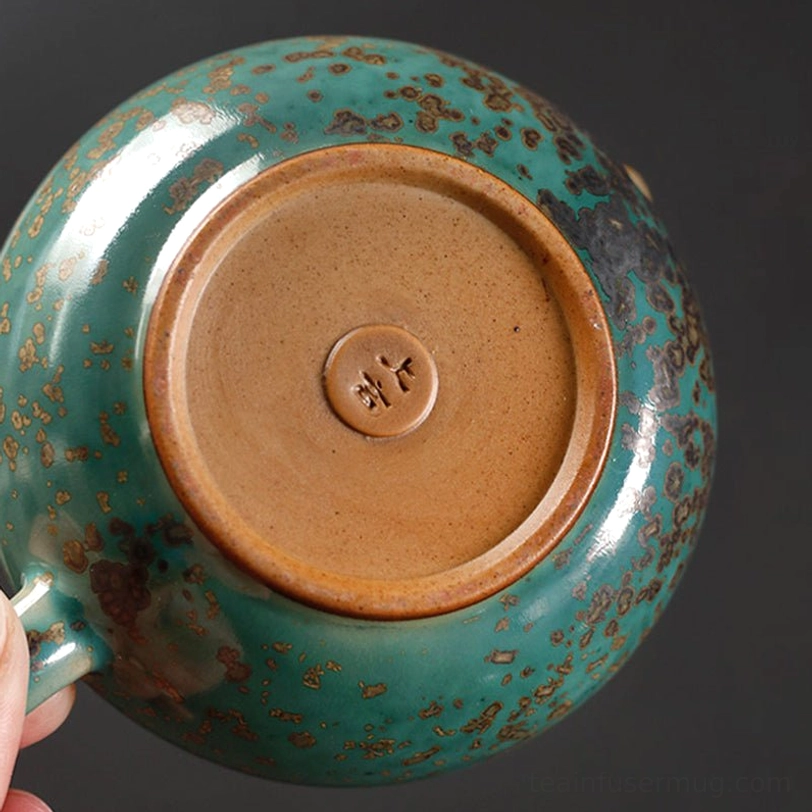 side profile of curved handle of the green ceramic teapot