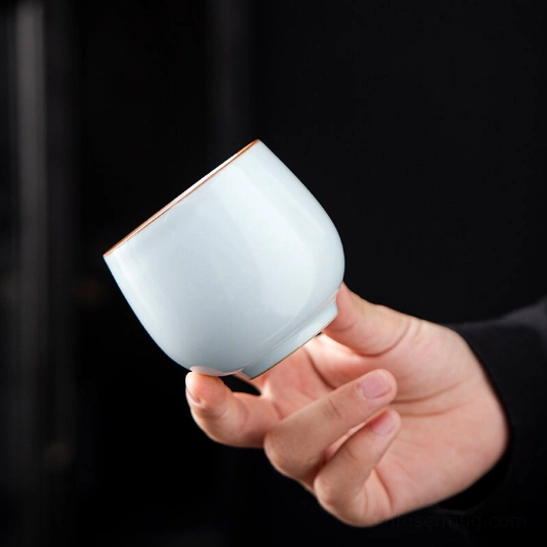 cyan antique Chinese porcelain tea cup held in hand to show size and grip