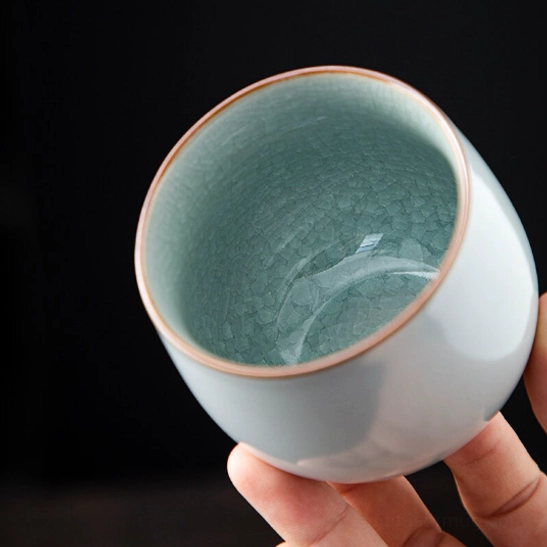 side view of cyan crackle glaze Chinese porcelain tea cup with gold rim