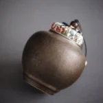 dark ceramic loose leaf tea storage canister with patterned cloth lid