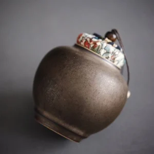 dark ceramic loose leaf tea storage canister with patterned cloth lid