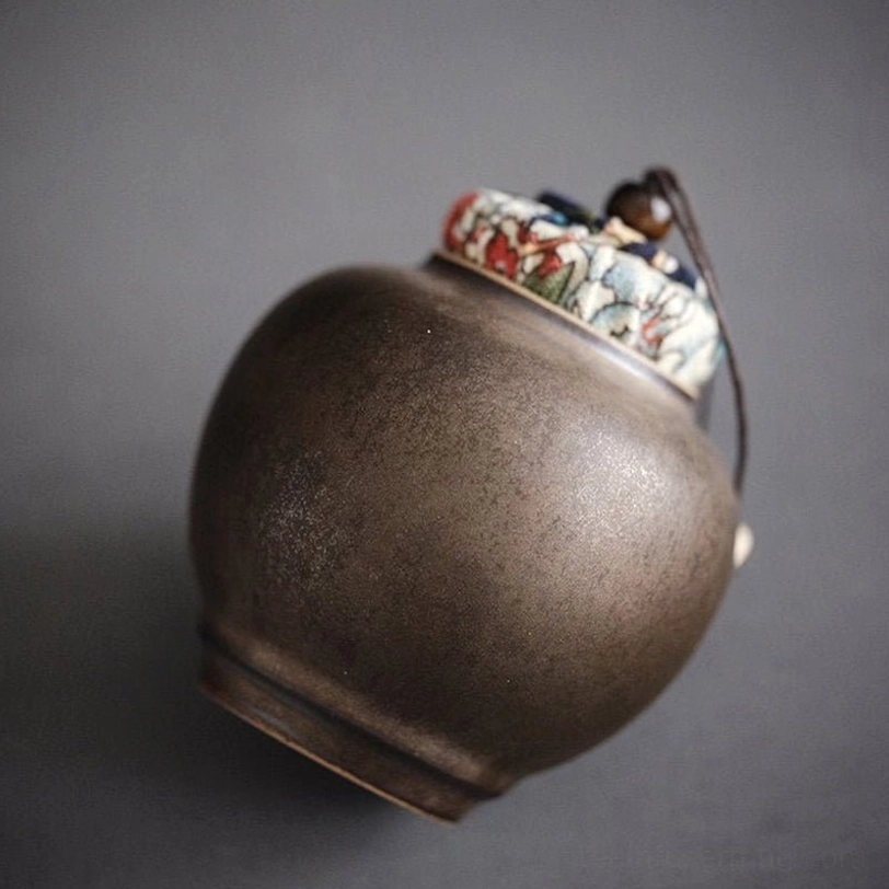 dark ceramic loose leaf tea storage canister with patterned cloth lid