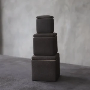 stacked dark gray ceramic tea storage canisters three sizes